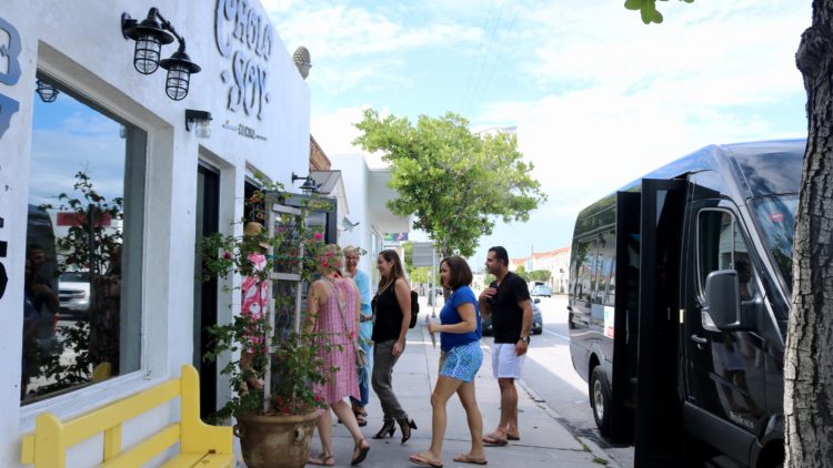 restaurants west palm beach people getting out of a black Mercedes van and going into a restaurant on a west palm beach food tour