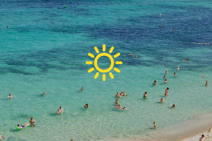 a group of people on a beach next to the ocean