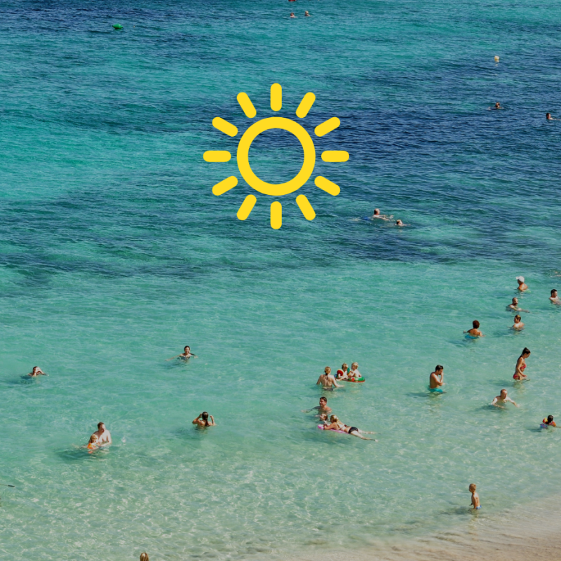 a group of people on a beach next to the ocean