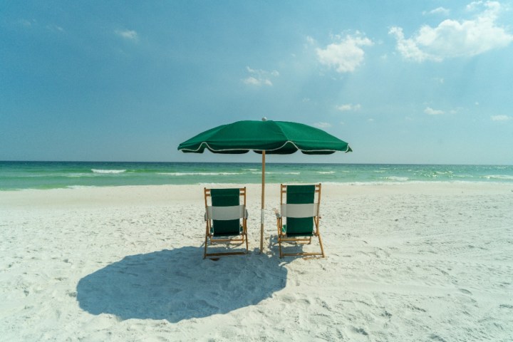 2 green chairs on a beach