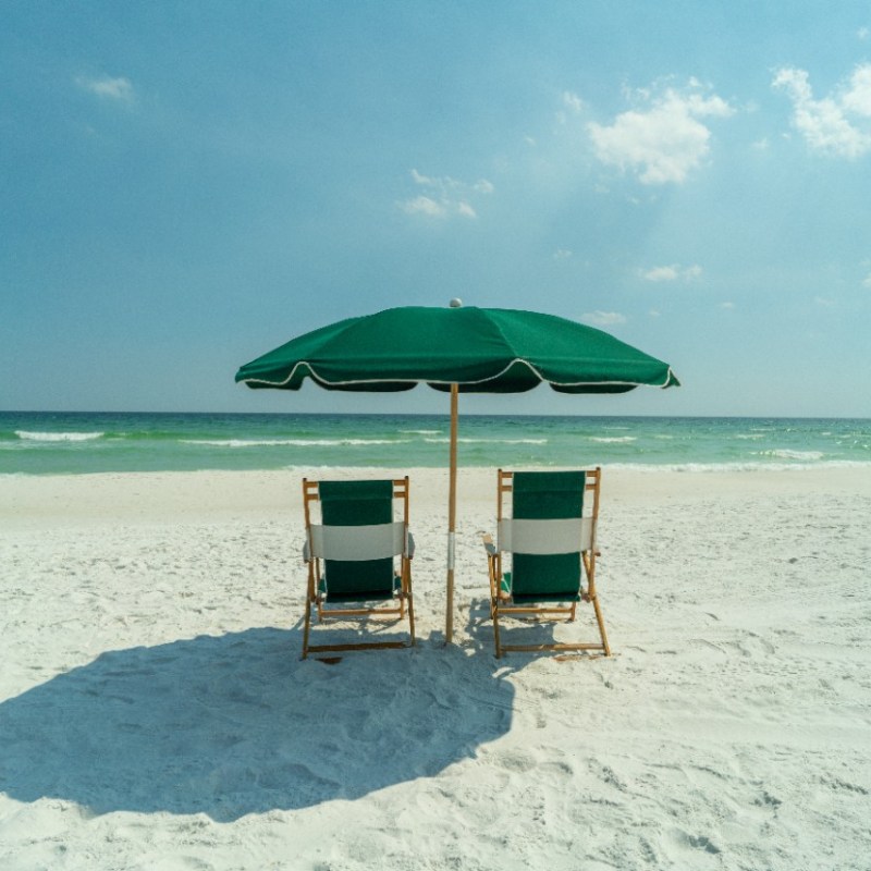 2 green chairs on a beach