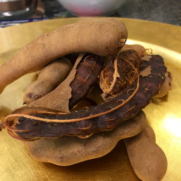 close up of tamarinds. some peeled, some whole