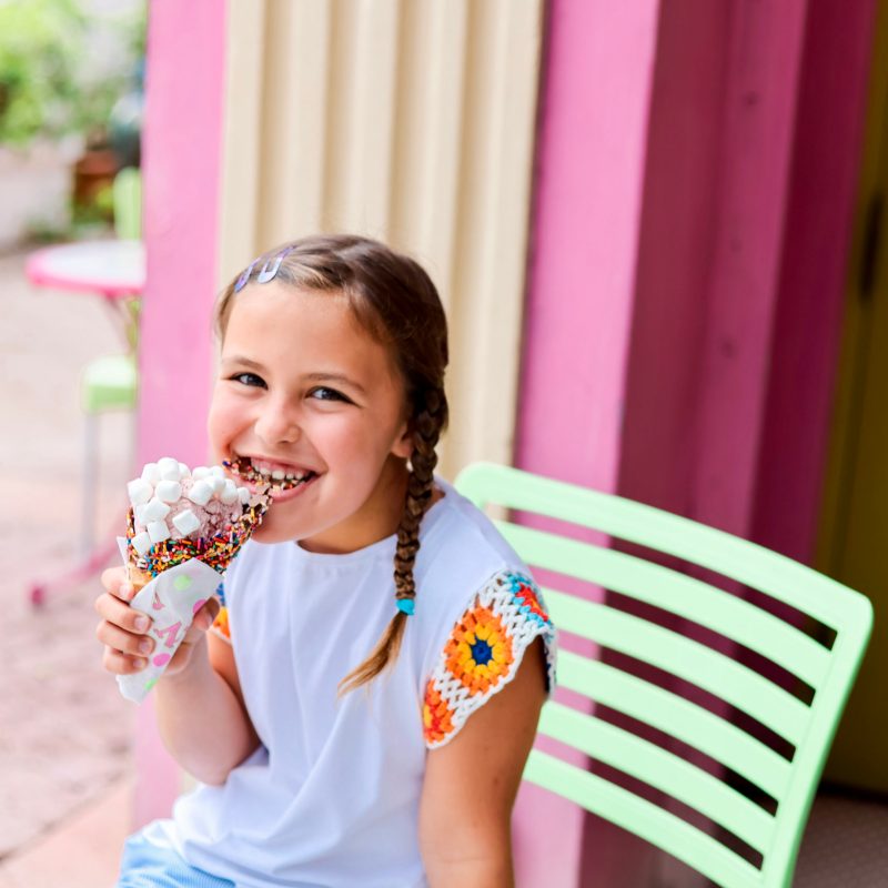 a little girl seating an ice cream cone