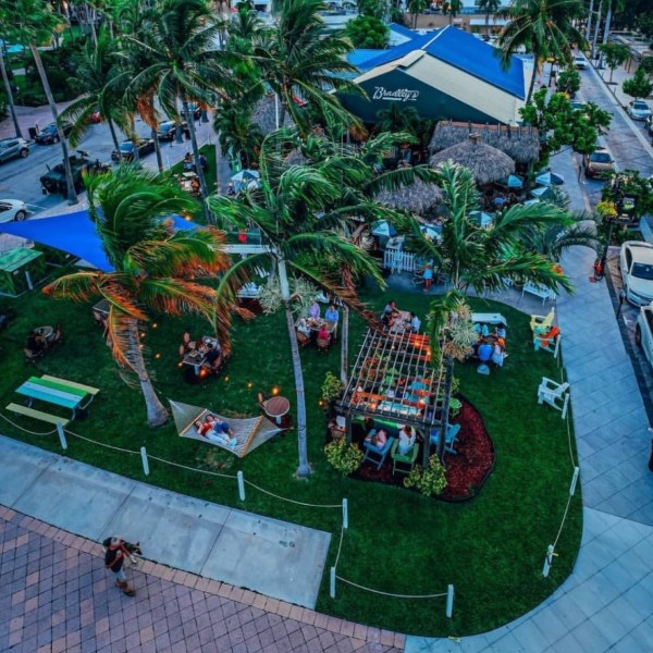 an arial view of an outdoor restaurant in west palm beach with palm trees and tiki huts