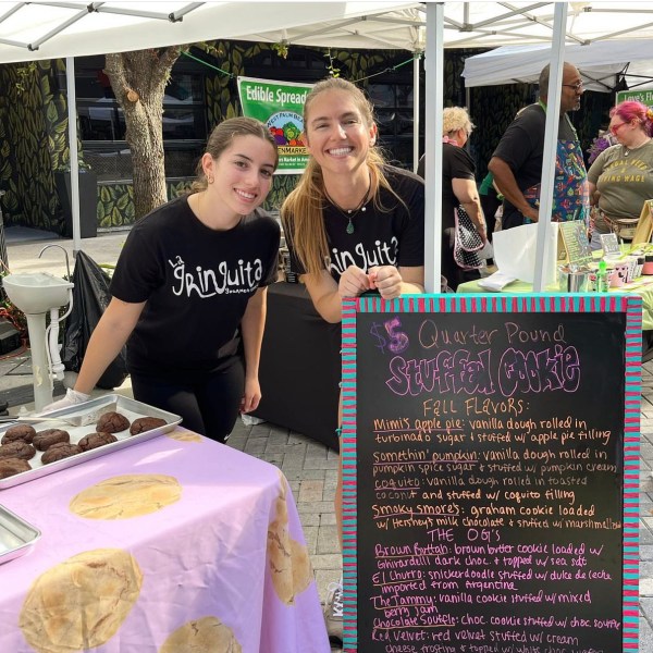 2 girls in a cookie booth at an outdoor market
