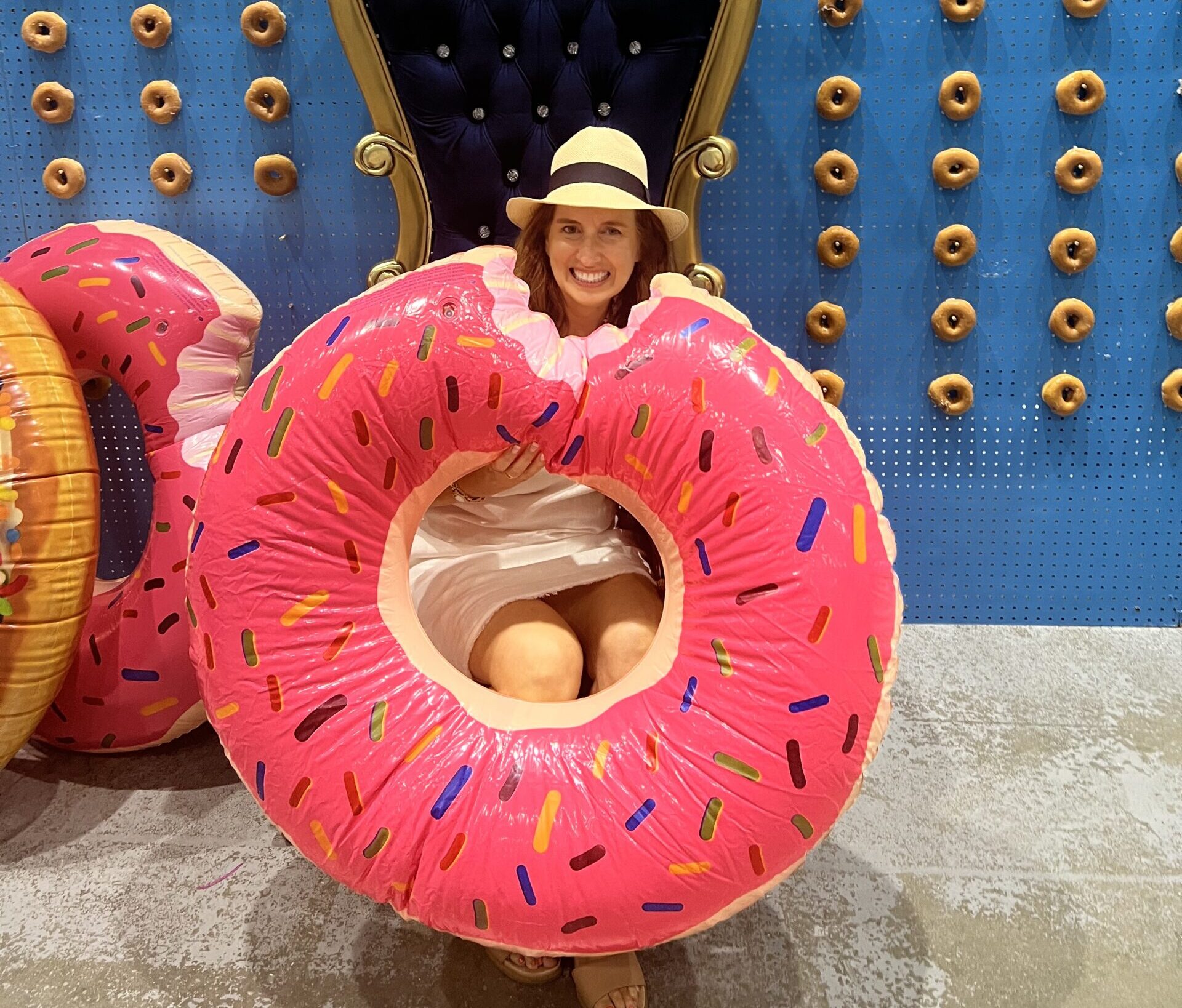 girl with a big blow up pink donut with sprinkles