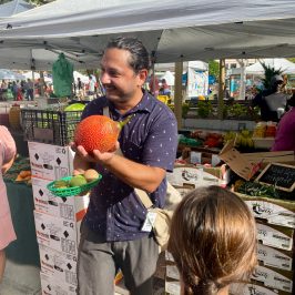 a man showing an exotic tropical fruit during a food tour