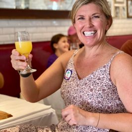a woman sitting at a table with a mimosa