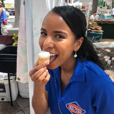 a woman eating a key lime tart with whipped cream