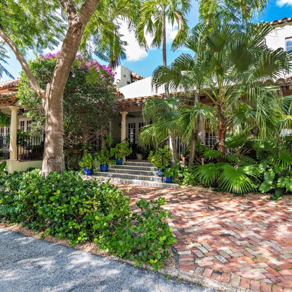 historic home with lush tropical landscaping