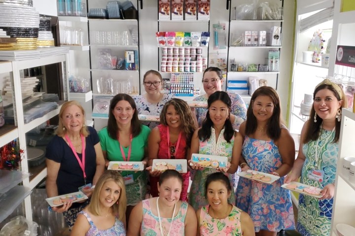 a group of people showing the cookies the decorated in a class