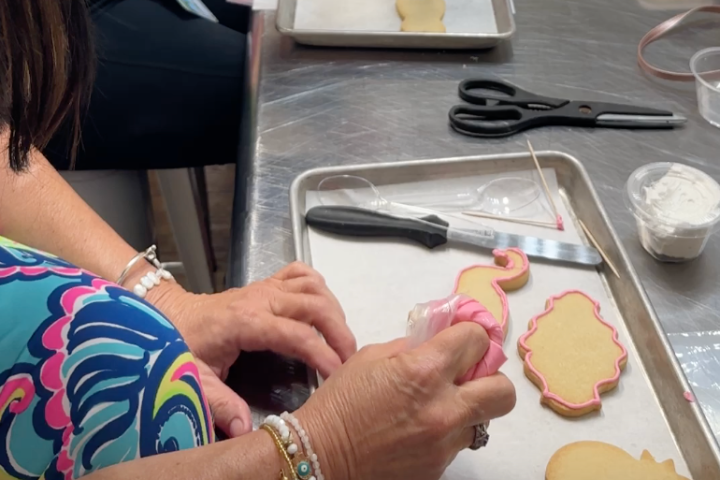 a girl painting cookies in a cookie decorating class