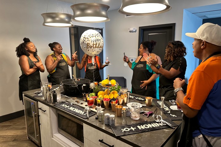 a group of people learning to make cocktails in a cocktail class