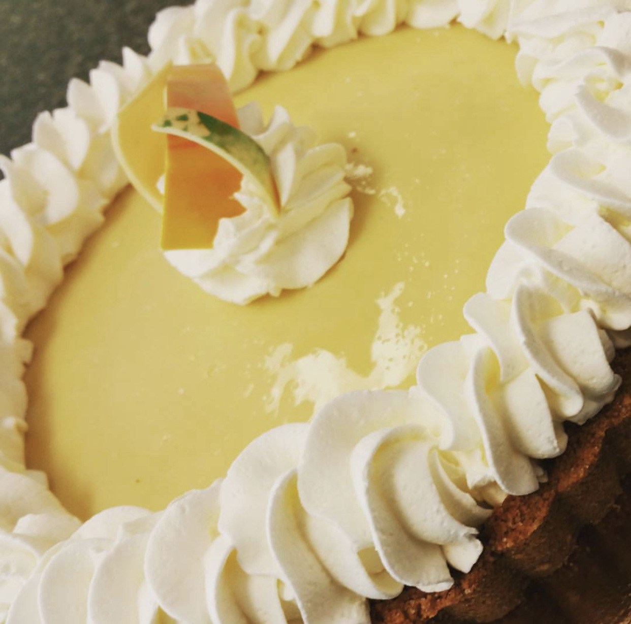 Close-up of a pie with whipped cream border and decorative topping.